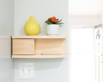 Curved floating shelf with concealed compartment