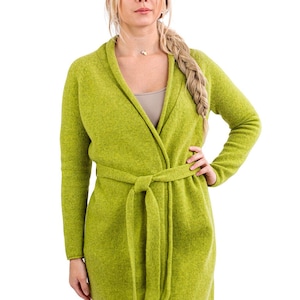 May include: A long-sleeved, green knitted cardigan with a shawl collar and a self-tie belt. The cardigan is made of a soft, lightweight fabric and has a relaxed fit.