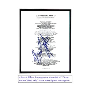 May include: A framed print featuring the lyrics to the song Thunder Road by Bruce Springsteen, printed in black text on a white background. A blue ink signature is overlaid across the center of the lyrics. The frame is a simple black border.