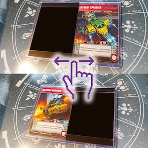 May include: Two Autobot Springer trading cards in protective sleeves. One card shows a yellow and green helicopter, the other a yellow car. The cards are displayed with a sliding effect, with the text "AUTOBOT SPRINGER" visible.