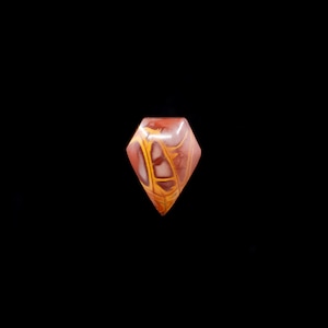 May include: A red, yellow, and white gemstone cabochon cut in a diamond shape.