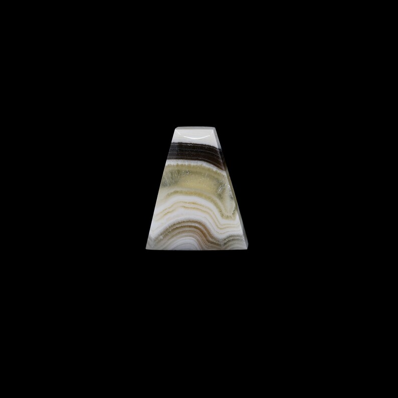 May include: A triangular shaped, white, green, and black onyx pyramid with a smooth, polished surface.