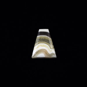 May include: A triangular shaped, white, green, and black banded agate gemstone.
