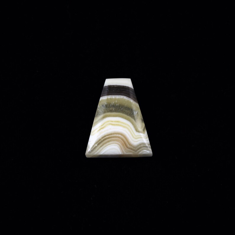 May include: A triangular shaped, white, green, and black banded agate gemstone.