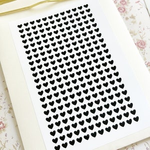 May include: A sheet of black heart stickers on a white background. The hearts are arranged in a staggered pattern.