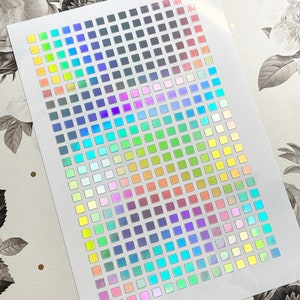 May include: A sheet of iridescent holographic stickers with a grid of small squares in various colors, including blue, green, yellow, orange, red, purple, and pink.