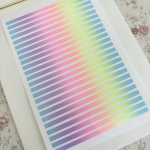 May include: A white paper with a rainbow gradient of horizontal stripes in pastel colors, including purple, blue, green, yellow, and orange. The paper is on a white clipboard with a gold clip.
