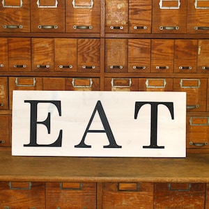 Metal &quot;EAT&quot; on wood plank