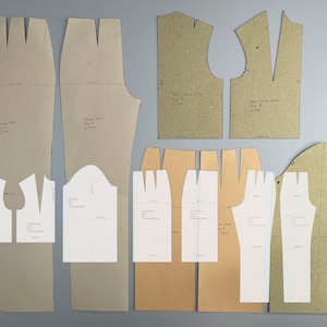 Peut inclure: Un ensemble de patrons de couture pour une robe et un pantalon. Les patrons sont imprimés sur du papier brun et vert et comprennent des instructions pour les tailles 8 et 10.