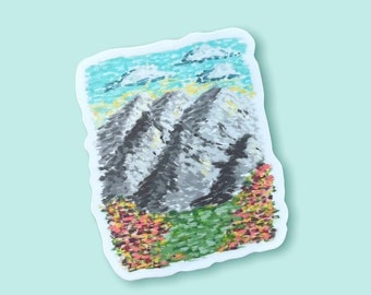 May include: A sticker featuring a painted illustration of a mountain range with a blue sky and white clouds. The mountains are gray and white with a green and orange foreground.