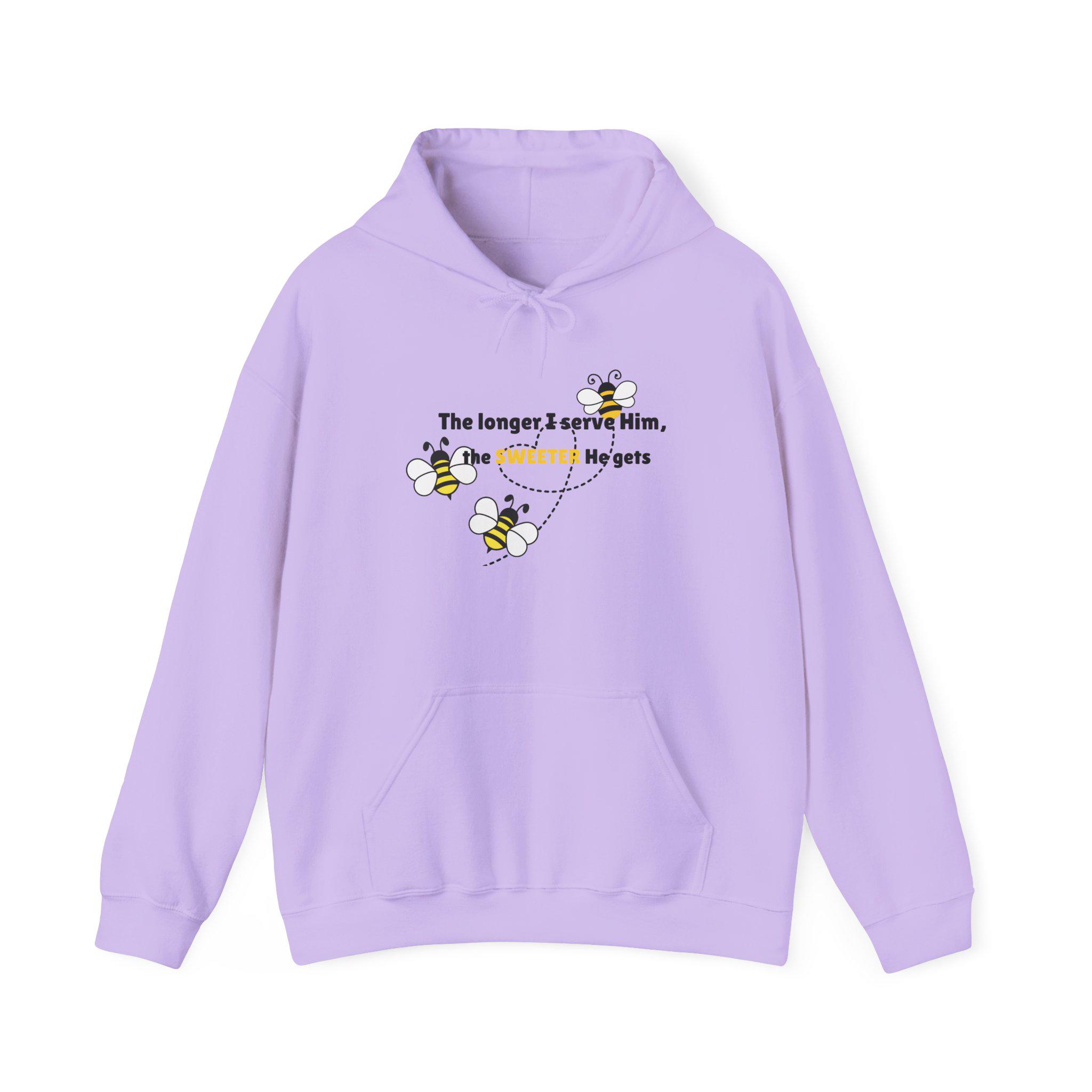 May include: A light purple hooded sweatshirt featuring a graphic of three small bees flying in a dotted path. The text printed on the front reads, The longer, I serve Him, the SWEETER He gets, with the word SWEETER highlighted in yellow.