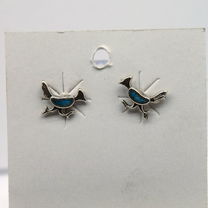 Puede incluir: Un par de pendientes de plata de ley con una incrustación de turquesa en forma de pájaro.