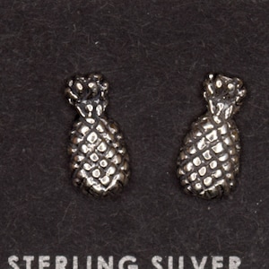 以下が含まれることがあります： 黒いカードに「Sterling Silver」と印刷された、スターリングシルバー製のパイナップルスタッドピアスのペアです。