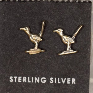 Puede incluir: Un par de pendientes de plata de ley con diseño de correcaminos. Los pendientes se muestran en una tarjeta negra con las palabras "Sterling Silver" impresas en ella.