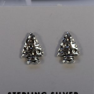 Op de afbeelding: Een paar oorbellen van sterling zilver in de vorm van pijlpunten. De pijlpunten hebben een getextureerd oppervlak en worden gepresenteerd op een witte kaart met de tekst "Sterling Silver" erop gedrukt.
