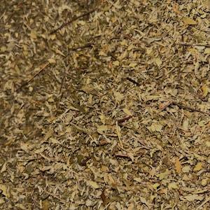 May include: A close-up of a pile of dried herbs, with a variety of colors and textures. The herbs are a mix of green, brown, and yellow, and they are all finely chopped.