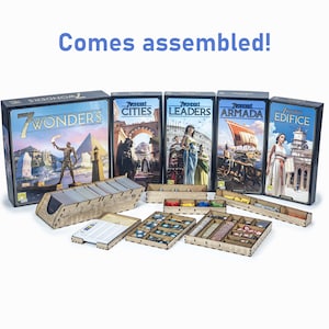 May include: A set of wooden game organisers for the 7 Wonders board game and its expansions. The organisers are made of light brown wood and have compartments for all the game components. The organisers are assembled and ready to use. The game boxes are in the background, with the titles "7 Wonders", "7 Wonders Cities", "7 Wonders Leaders", "7 Wonders Armada", and "7 Wonders Edifice" visible.