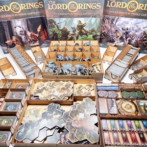 Könnte beinhalten: Ein Holzorganizer für das Brettspiel Der Herr der Ringe: Reisen in Mittelerde. Der Organizer verfügt über Fächer für Karten, Spielsteine und Miniaturen. Der Organizer ist aus Holz gefertigt und hat eine natürliche Oberfläche.