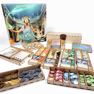 Puede incluir: Organizador de madera para el juego de mesa Khora: Rise of an Empire. El organizador incluye compartimentos para cartas, fichas, dados y otros componentes del juego. El organizador está hecho de madera y tiene un acabado natural.
