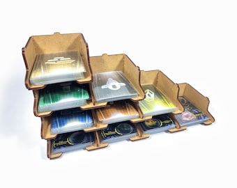Puede incluir: Un organizador de madera con múltiples compartimentos para guardar cartas. El organizador está hecho de madera marrón y tiene un diseño apilado. Los compartimentos están llenos de varias cartas, incluidas cartas verdes, azules y amarillas.