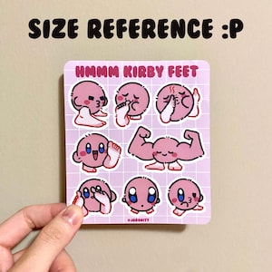 May include: A sheet of pink stickers featuring various illustrations of Kirby, a pink video game character, with the text "Hmmm Kirby Feet" at the top.