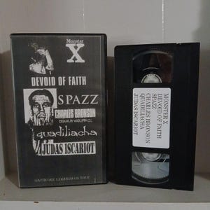 May include: A black VHS tape and case with the text "Monster X" and band names including "Devoid of Faith" and "Spazz." The case also reads "Hardcore Legends on Tour."