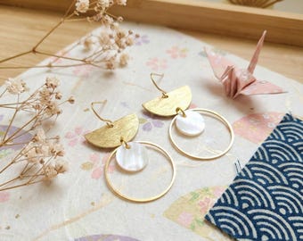 May include: A pair of dangle earrings featuring a brushed gold-tone semi-circle top piece connected to a thin gold-tone wire hoop. A small, round, iridescent white mother-of-pearl disc is suspended within the center of each gold hoop.