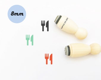 May include: Two wooden stamps with a black and white fork and knife design. The stamps are 8mm in diameter and are labeled "Just Go Stamps".