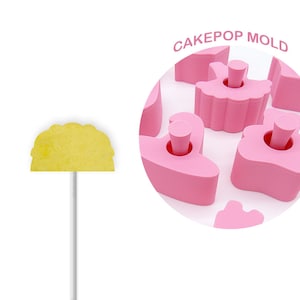 Peut inclure: Moule à cake pops rose avec plusieurs cavités en forme de ballerine. Le moule est en silicone et est conçu pour créer des cake pops qui ressemblent à des ballerines. Le moule est présenté avec un cake pop jaune sur un bâton.