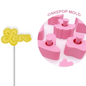 May include: Pink cake pop mold with a variety of shapes, including a ballerina, a heart, and a cloud. The mold is made of silicone and is designed to create cake pops that are easy to remove. The mold is shown with a yellow cake pop that says "Love" on it.