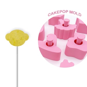 May include: Pink cake pop mold with various shapes, including a ballerina, a swan, and a heart. The mold is made of silicone and is designed to create cake pops that are easy to remove. CAKEPOP MOLD is written in white letters on a pink circle.