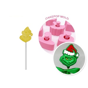 May include: Pink silicone cake pop mold with six cavities shaped like the Grinch wearing a Santa hat. The mold is shown with a green Grinch cake pop and a yellow Santa cake pop.