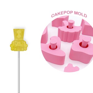 May include: Pink cake pop mold with a ballerina design. The mold has eight cavities and is made of silicone.  The mold is shown with a yellow cake pop in the shape of a ballerina.