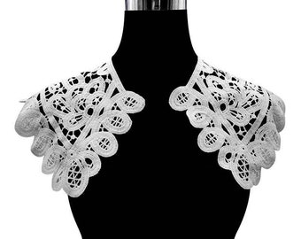 May include: White lace collar with a delicate floral pattern. The collar is made of a soft, lightweight fabric and has a scalloped edge.