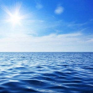 以下が含まれることがあります： 白い雲と輝く太陽が青い空に広がり、穏やかな青い海を照らしています。