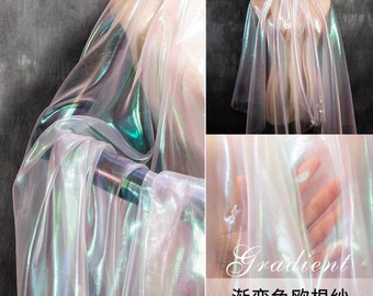 May include: Iridescent sheer fabric with a gradient of colors, including pink, green, and blue. The fabric is translucent and has a shimmering effect. The text "Gradient" and "渐变色欧根纱" is visible in the image.