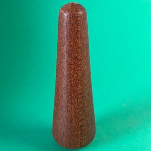 May include: A brown wooden finial with a smooth, rounded top and a slightly pointed bottom.