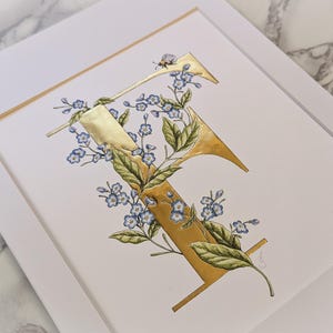 Impresión dorada a mano con la frase F is for Forget-Me-Not. Una letra F dorada con nomeolvides entrelazados y un abejorro. Hermosa para la habitación de un niño.
