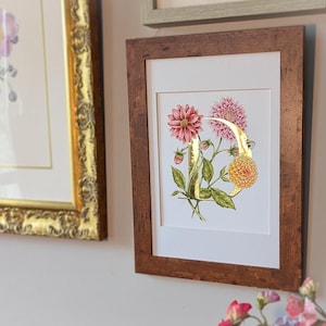 Estampado dorado con la letra D de Dahlia. Una letra D dorada con dalias entrelazadas y un abejorro. Ideal para las D de tu vida o para la habitación de un bebé.