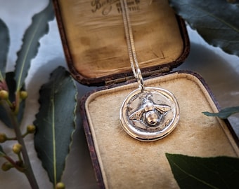 Silver Bee Wax Seal Pendant. A silver bee set within shiny raised edges, made to look like an antique wax seal. With adjustable silver chain