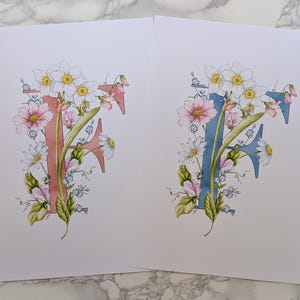 Lámina artística de la F de Flora. Una letra F azul o rosa con flores pastel entrelazadas y un abejorro. Ideal para una habitación infantil o una guardería.
