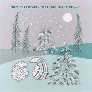 May include: A fabric pattern with a winter scene featuring two polar bears, snow-covered trees, and snowflakes. The bears have patterned details in shades of green and gray. The text "PRINTED FABRIC PATTERN, NO THREADS" is at the top.