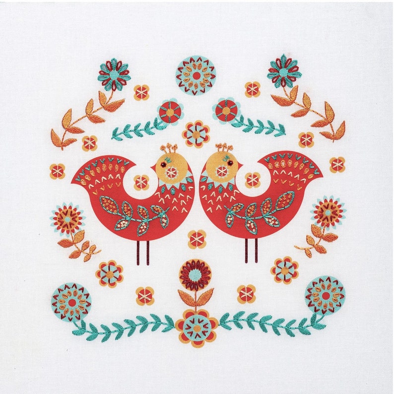 Folk art embroidery kit showing two red Scandi style birds decorated with simple embroidery stitches, surrounded by embroidered flowers in teal, red and apricot.