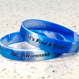 May include: Two blue and white silicone wristbands with the text "Let's Find A Cure!" and "ALS Awareness" printed in black.