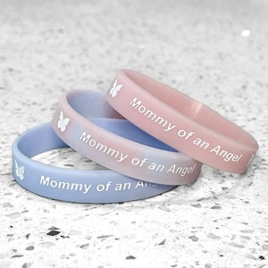 May include: Three silicone wristbands in pink and blue with the text "Mommy of an Angel" and a butterfly design.