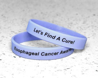 May include: Two purple silicone wristbands with the text "Let's Find A Cure!" and "Esophageal Cancer Awareness" printed in black.