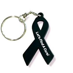May include: Black ribbon keychain with the text "Let's Find A Cure!" printed in white.