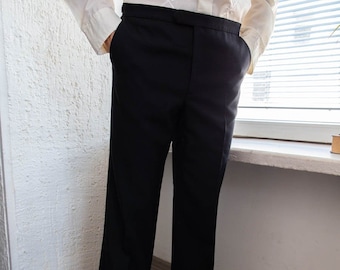 May include: A pair of black dress pants with a straight leg fit. The pants have a flat front and a zipper fly.