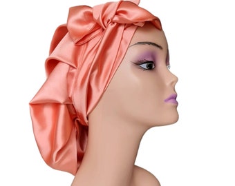 Può includere: Un turbante per capelli in raso color pesca con un fiocco in cima. Il turbante è progettato per proteggere i capelli durante il sonno.