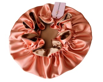 Può includere: Un berretto in raso color pesca con fodera in raso marrone. Il berretto è raccolto in cima e ha un'etichetta che recita "Bonita's Satin Bonnet".